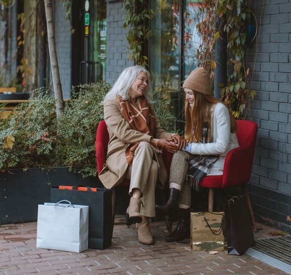 A woman and a girl are sitting in chairs talking to each other