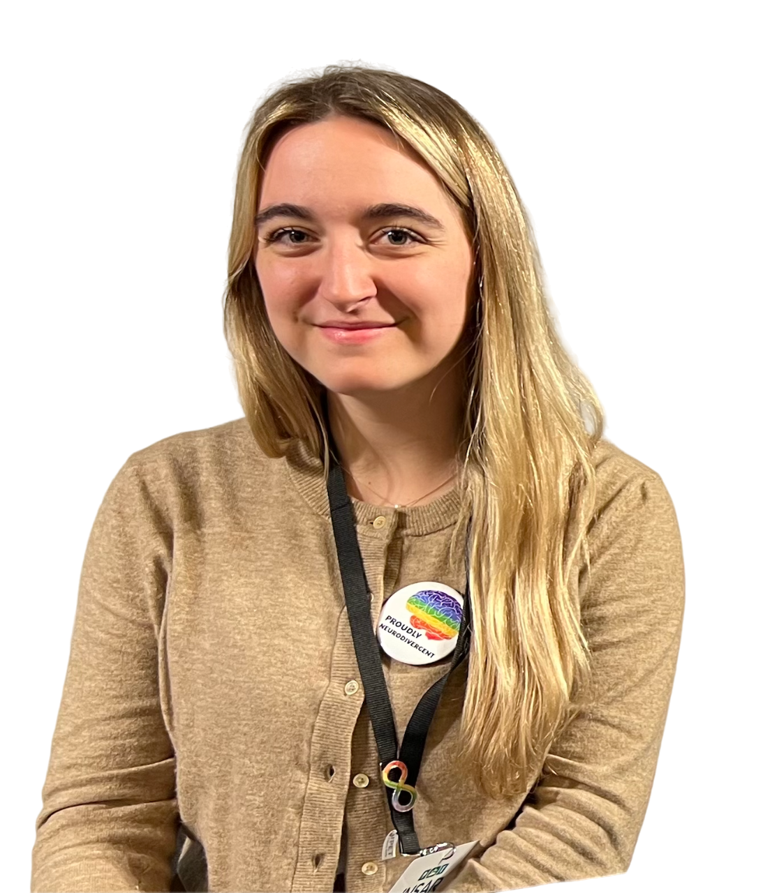 A woman wearing a tan cardigan and lanyard is smiling at the camera.