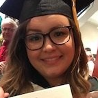 A woman wearing a graduation cap and gown is holding a diploma.