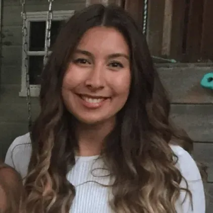 A woman with long brown hair is smiling for the camera.