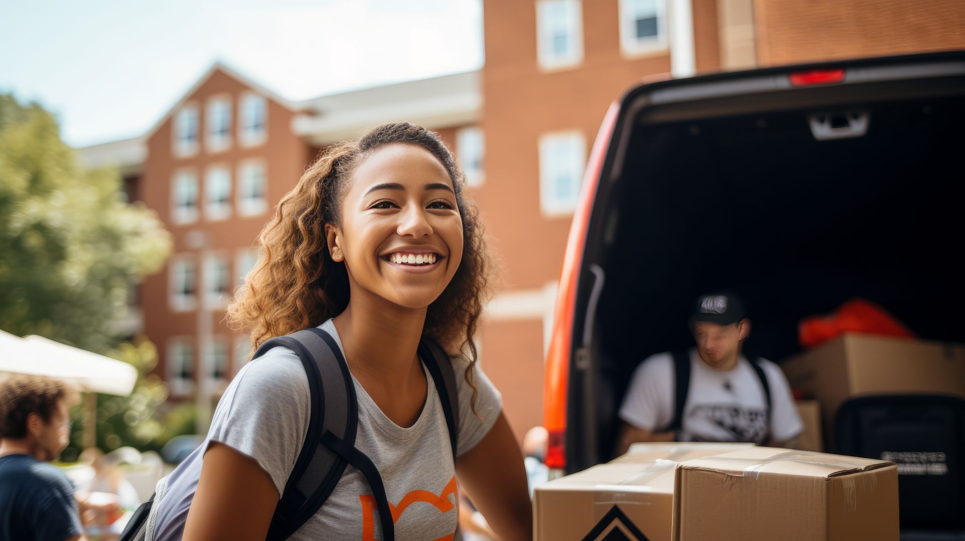 A woman is standing in front of a van with boxes in the back.