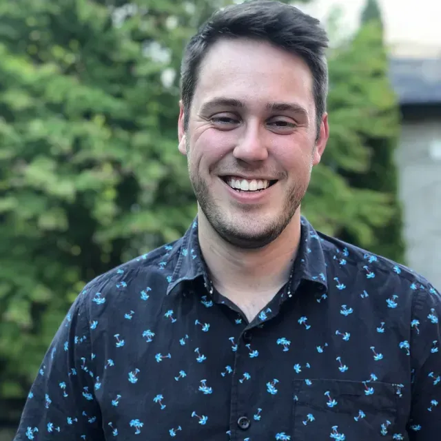 A man in a blue shirt is smiling for the camera.