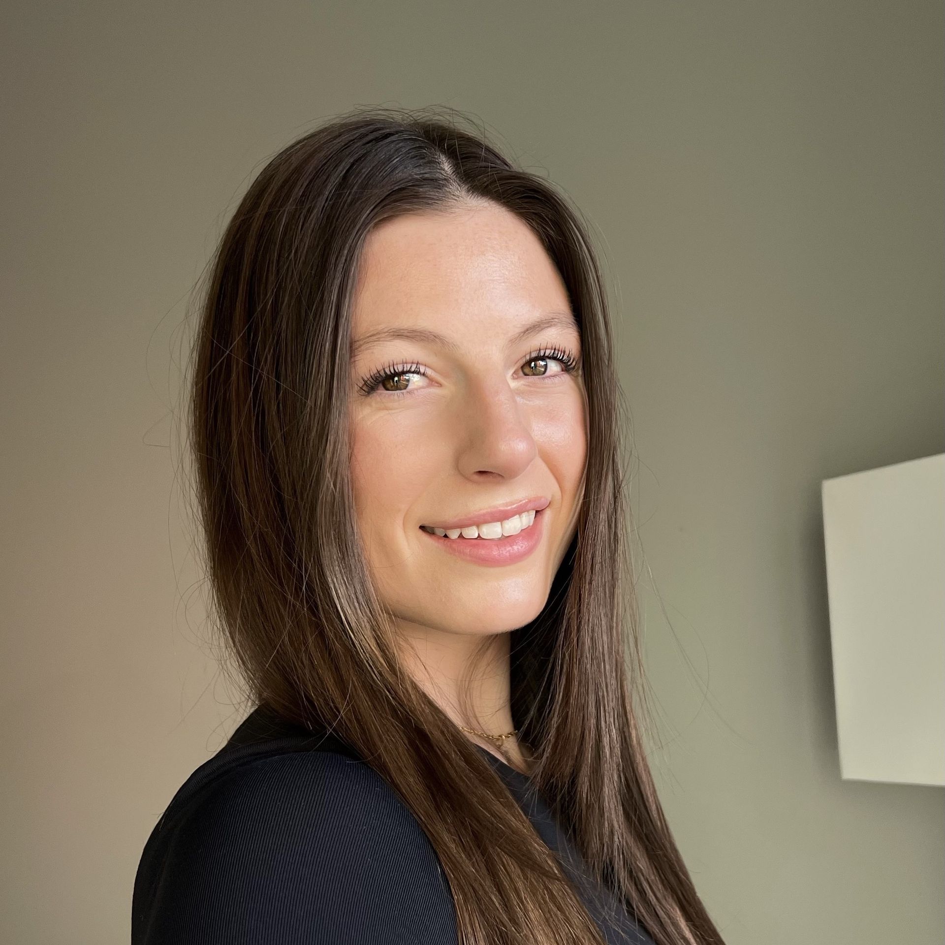 A woman wearing a black shirt is smiling for the camera.
