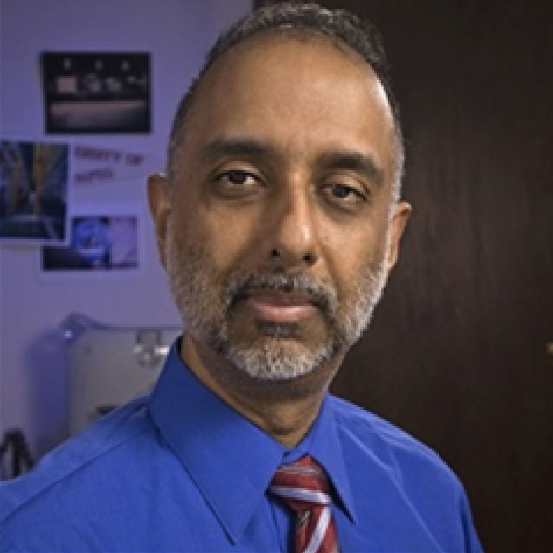 A man with a beard wearing a blue shirt and tie