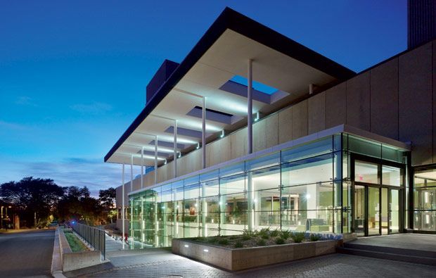 A large building with a lot of windows is lit up at night