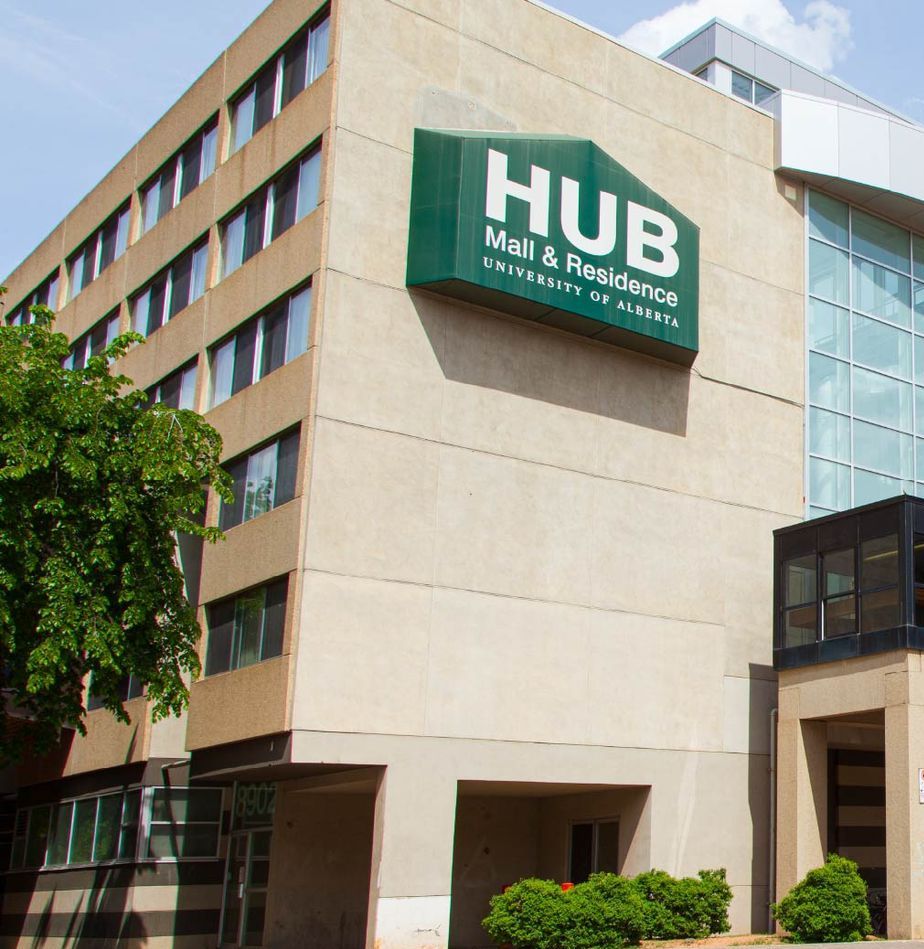 A building with a green sign that says hub mall & residence