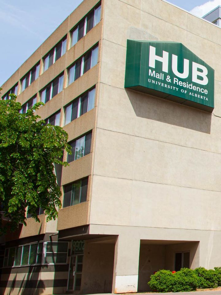 A building with a green sign that says hub mall & residence