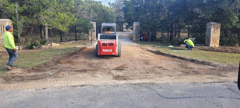A red bobcat is driving down a dirt road.