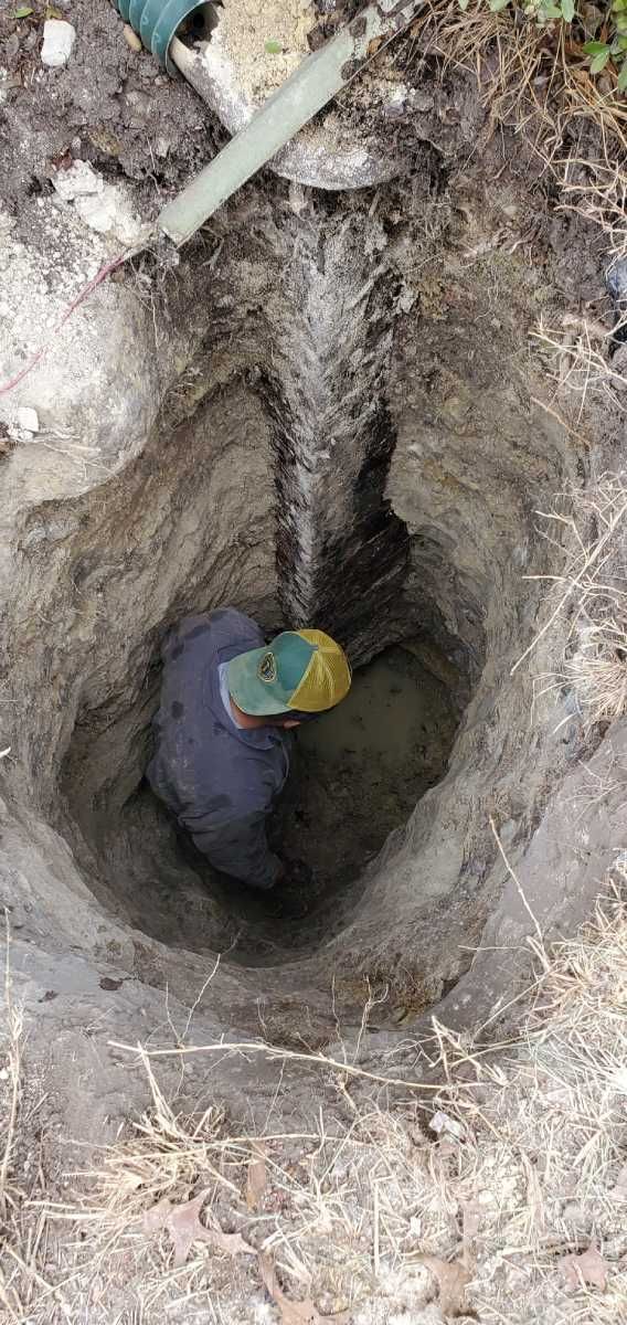 A man is sitting in a hole in the ground.