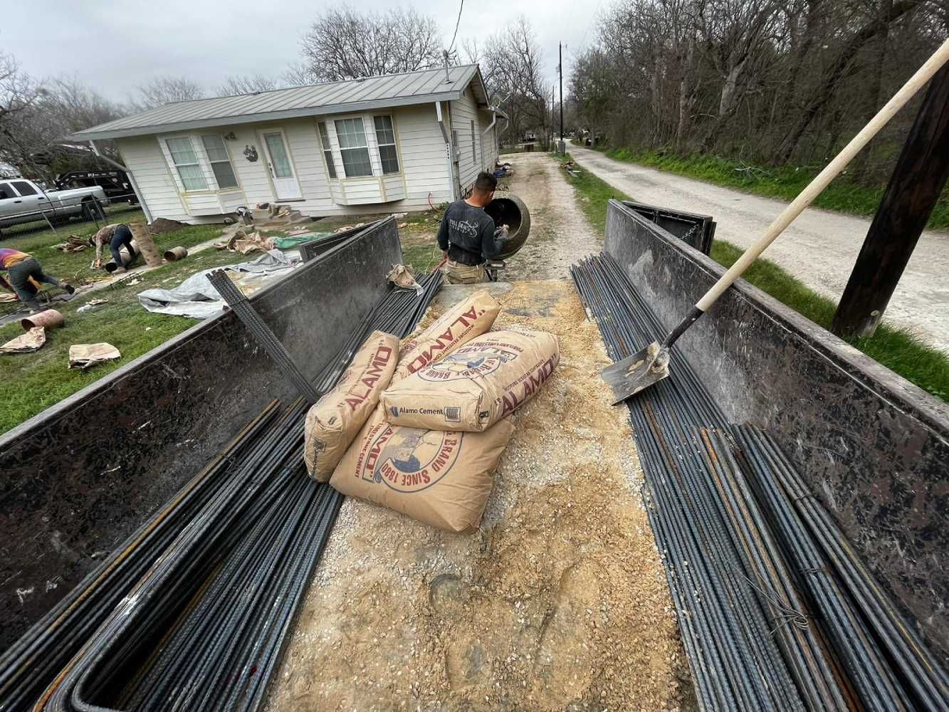 A truck filled with bags of cement and a shovel.