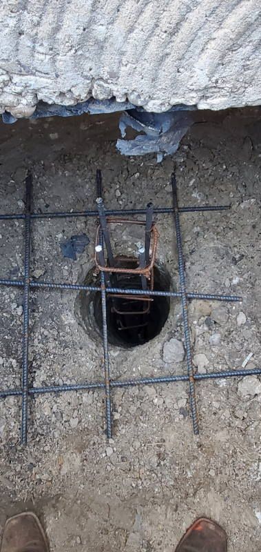 A person is standing next to a hole in the ground.