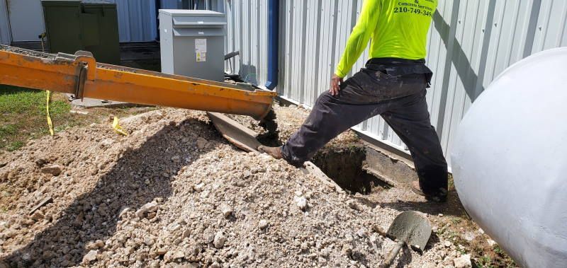A man is digging a hole in the ground with a shovel.
