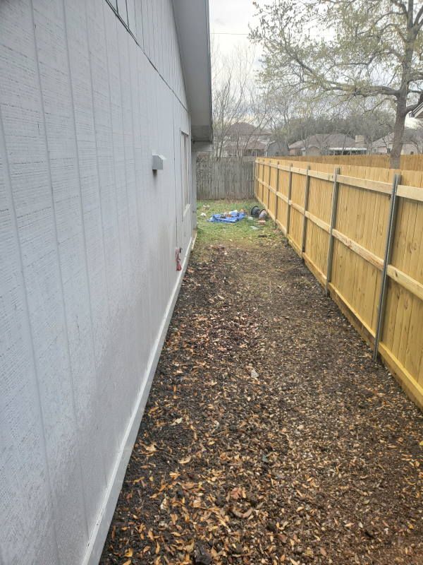A wooden fence along the side of a house.