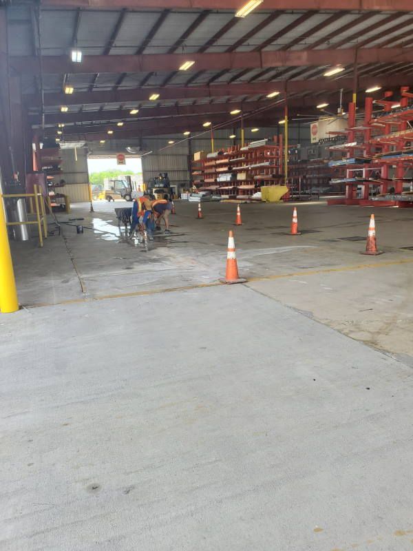 A warehouse with a lot of orange cones on the floor