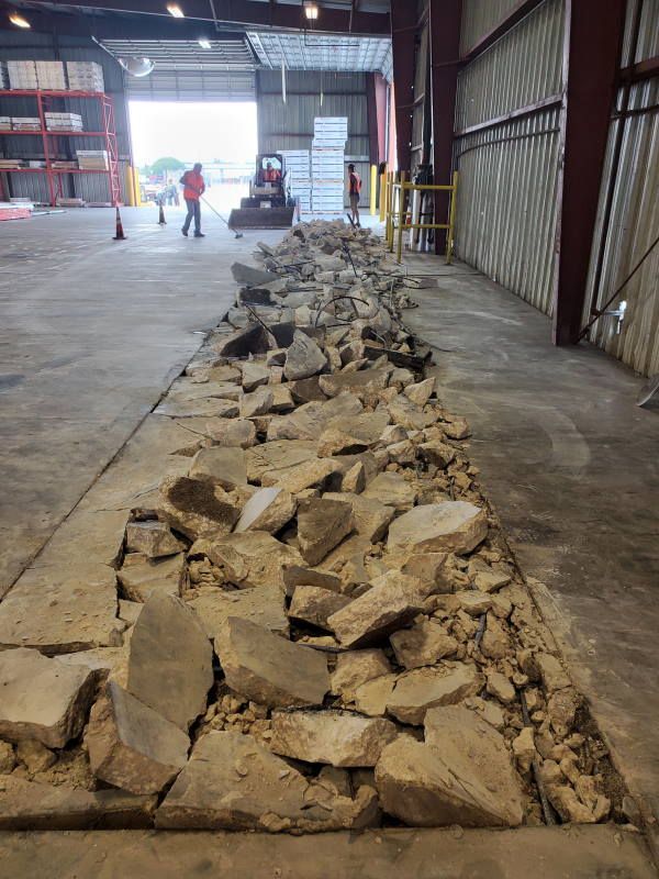A large pile of rocks is sitting on the ground in a warehouse.