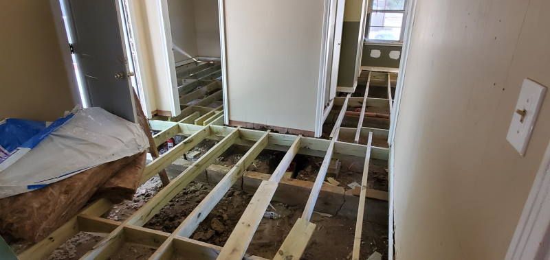 A hallway with a wooden floor under construction in a house.