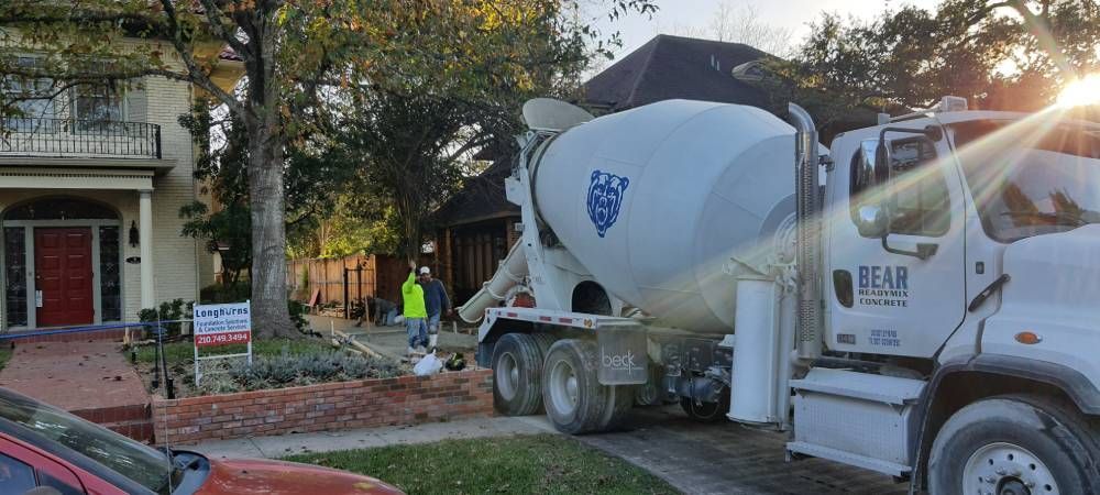 A concrete mixer truck is parked in front of a house.