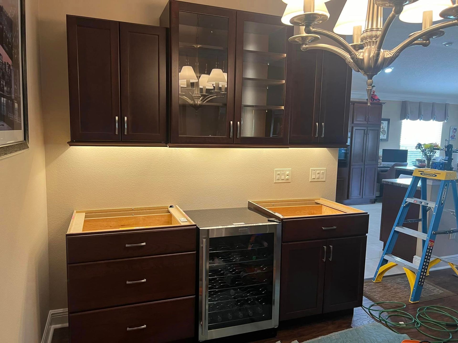 A kitchen with wooden cabinets and a stainless steel refrigerator.
