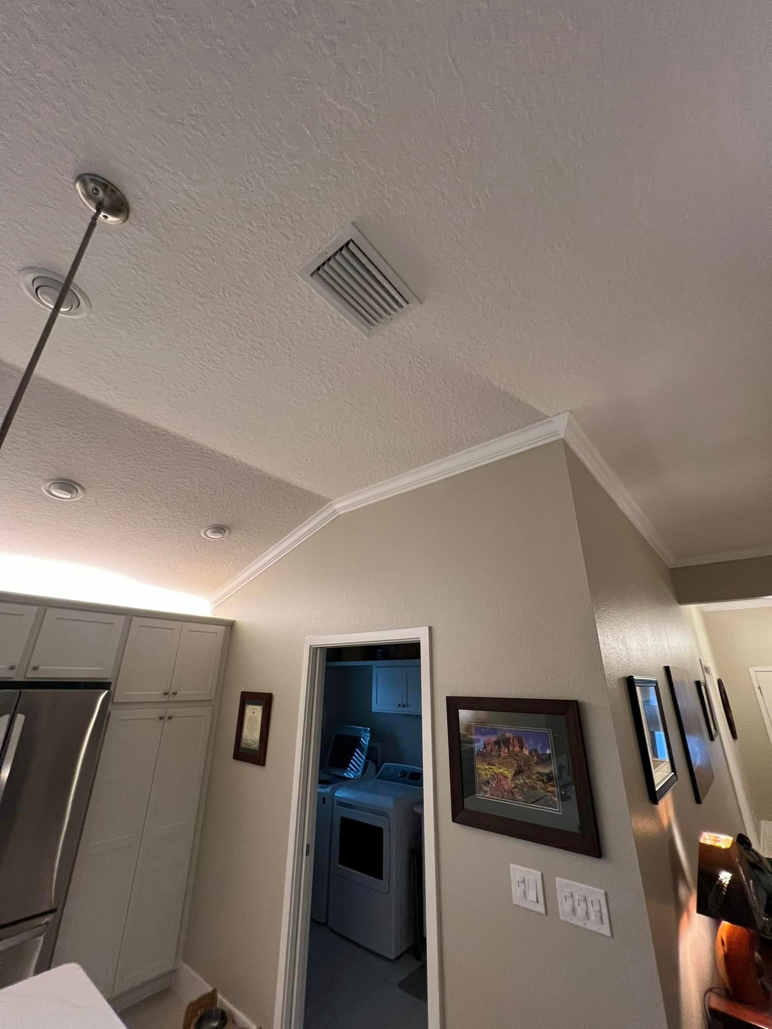 A kitchen with a ceiling fan and a door leading to a laundry room.