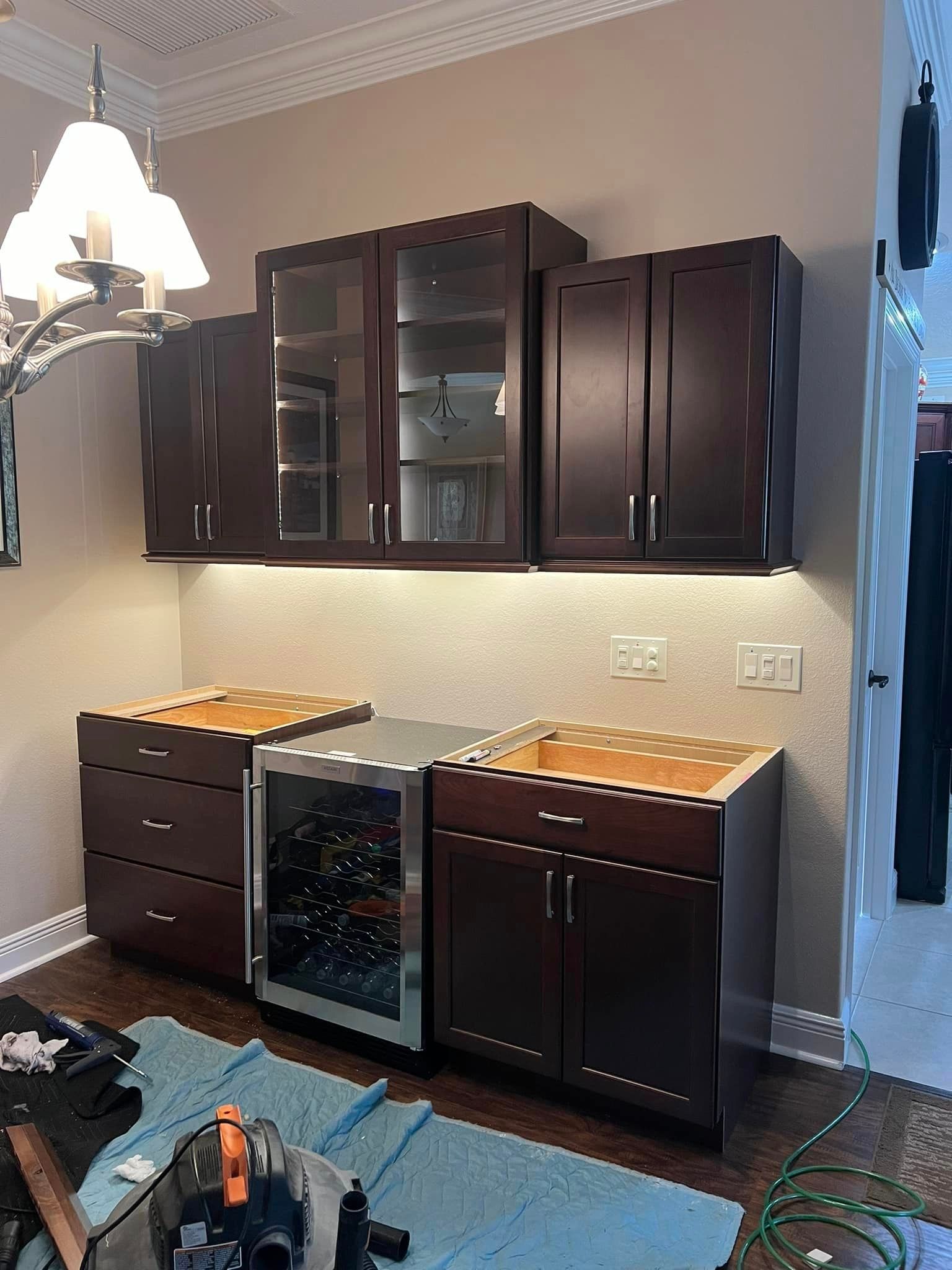 A kitchen with brown cabinets and a wine cooler.
