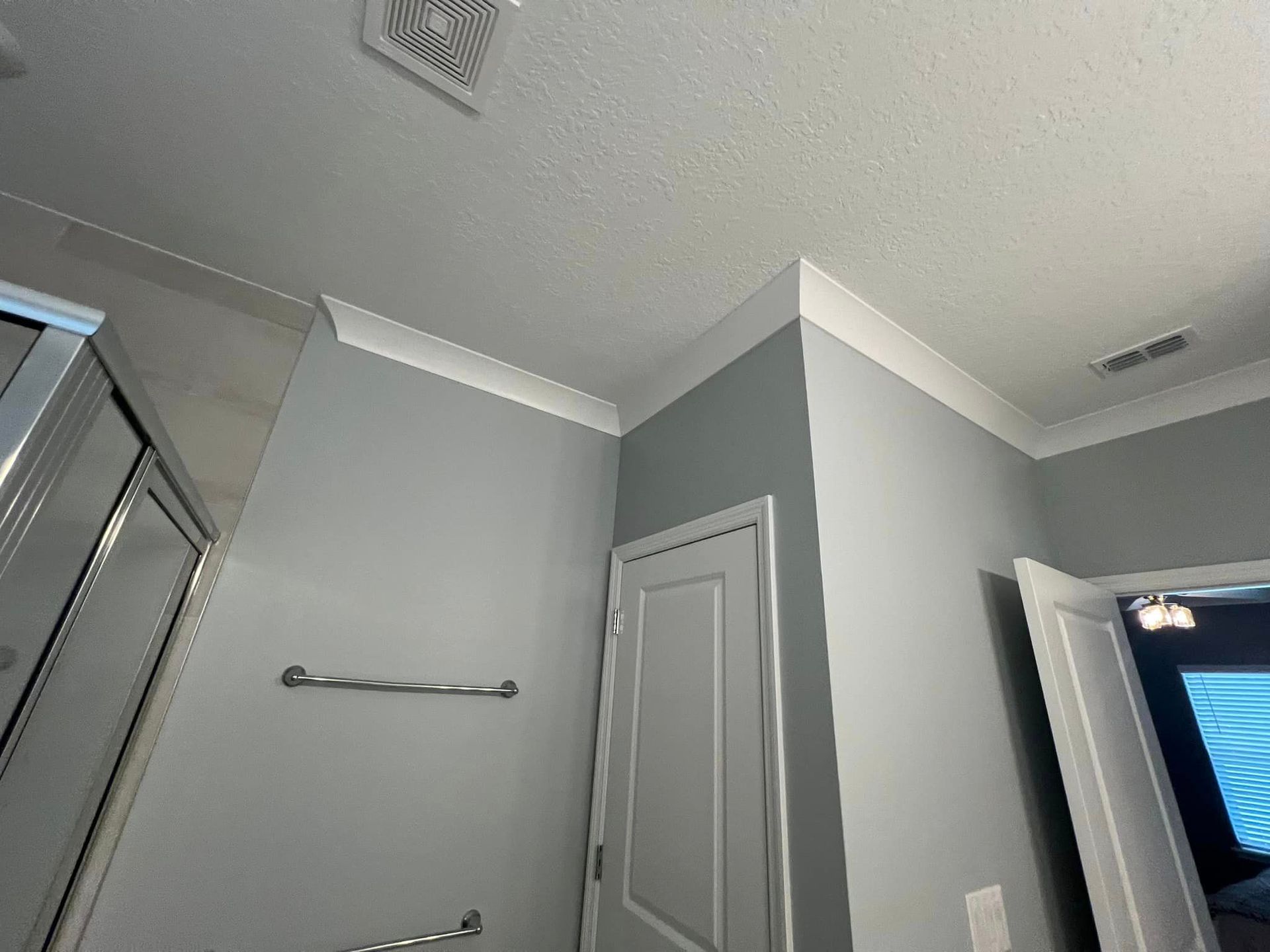 A bathroom with a door and a towel rack.