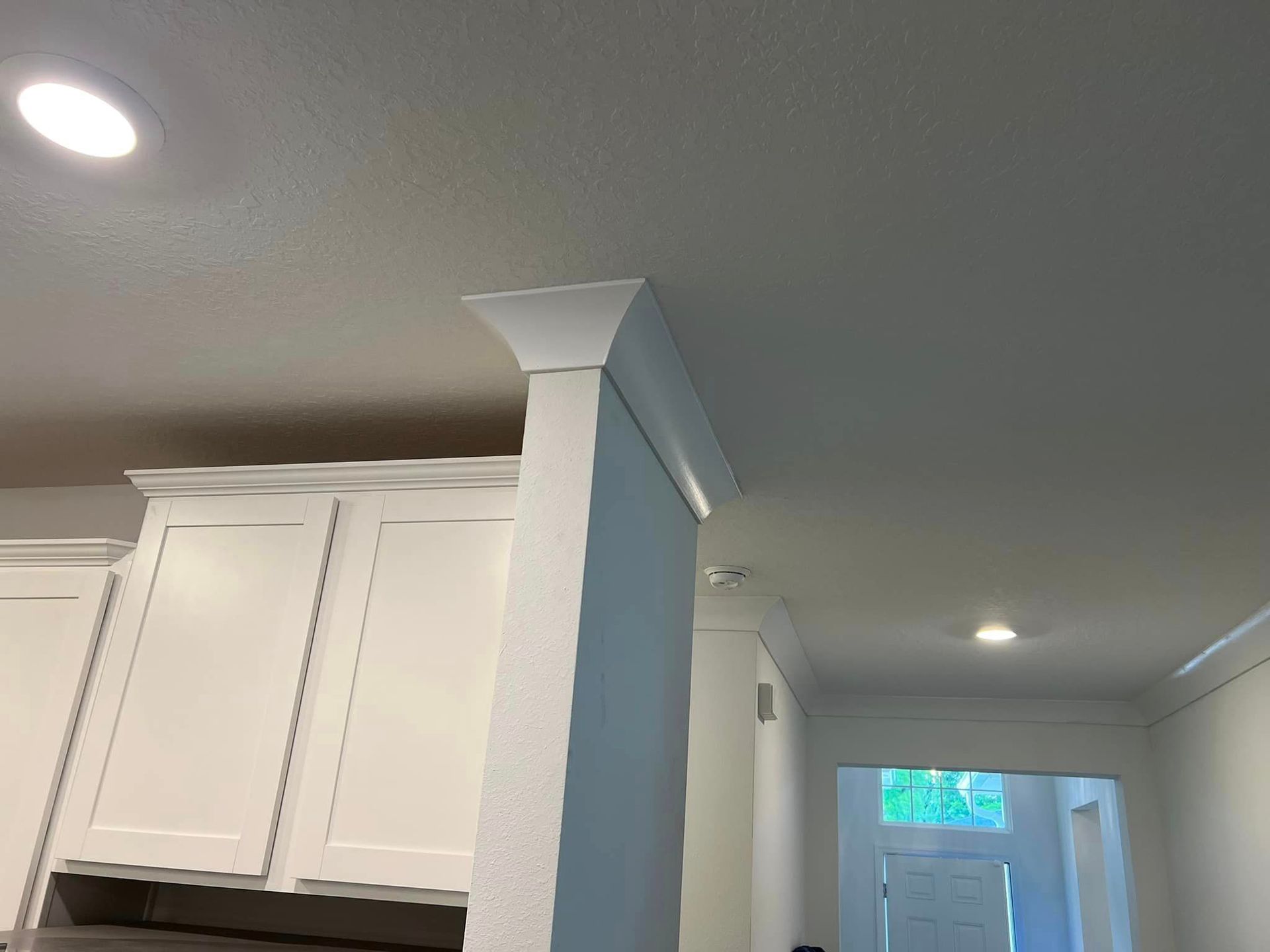 A kitchen with white cabinets and a white ceiling