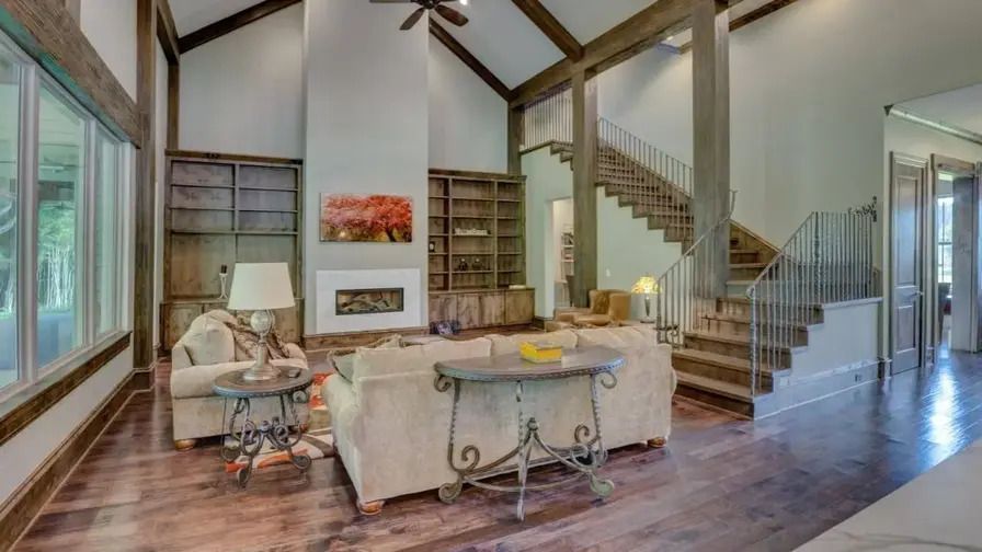 A cozy living room with a fireplace and stairs.