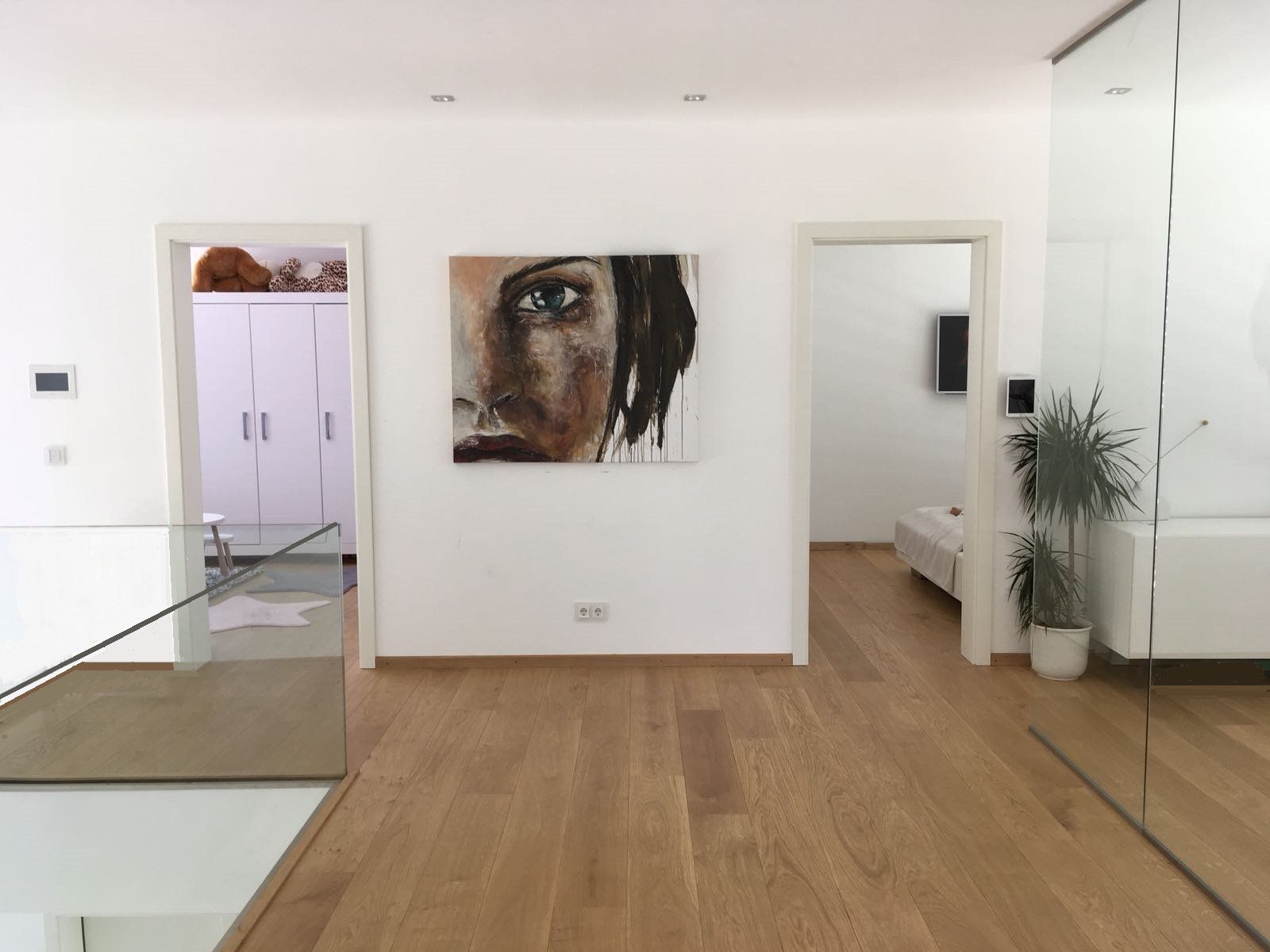 Ein Flur mit einem Gemälde eines Frauengesichts an der Wand