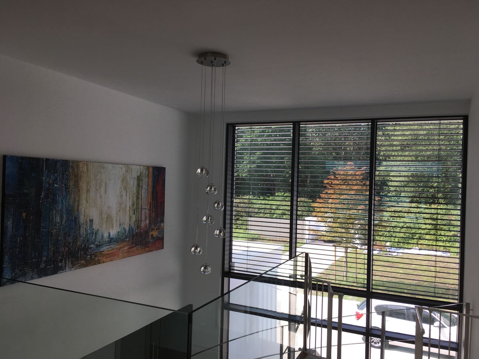 Ein Raum mit einem großen Fenster und einem Gemälde an der Wand.