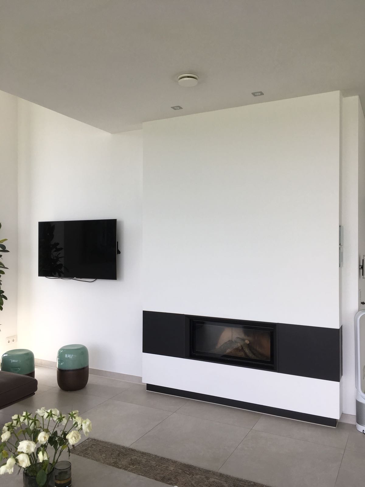 Ein Wohnzimmer mit Kamin und einem Flachbildfernseher an der Wand.