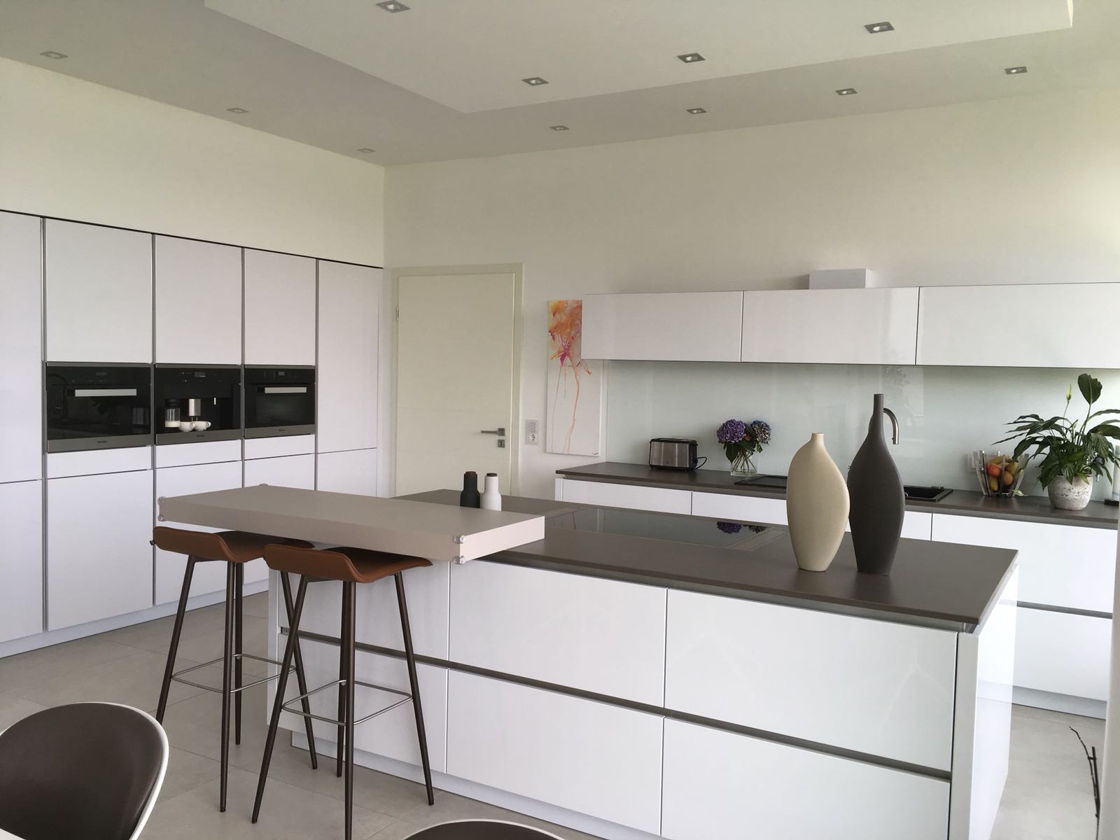 Eine Küche mit weißen Schränken und einer großen Insel in der Mitte