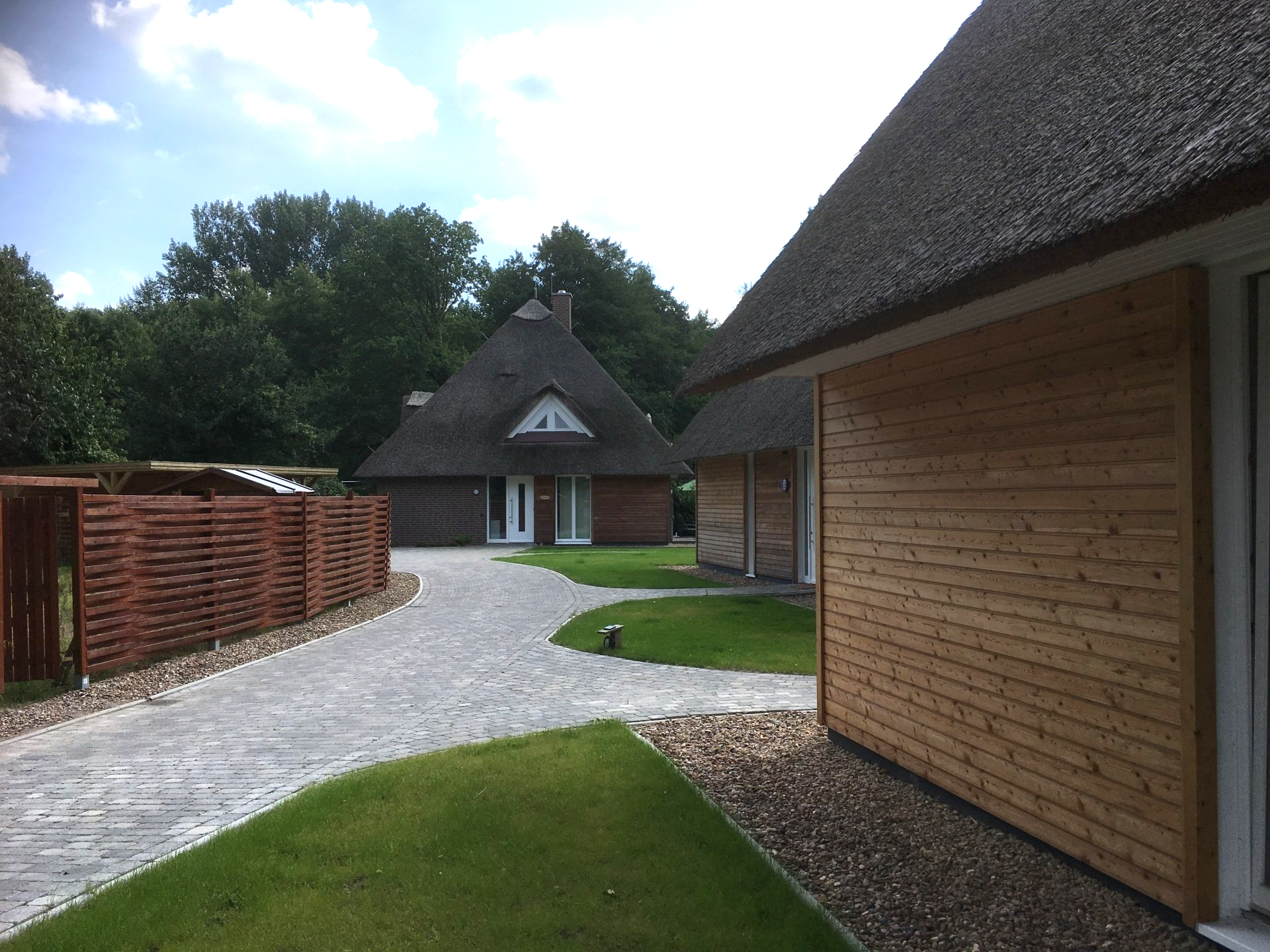 Ein Haus mit Strohdach steht neben einem anderen Haus