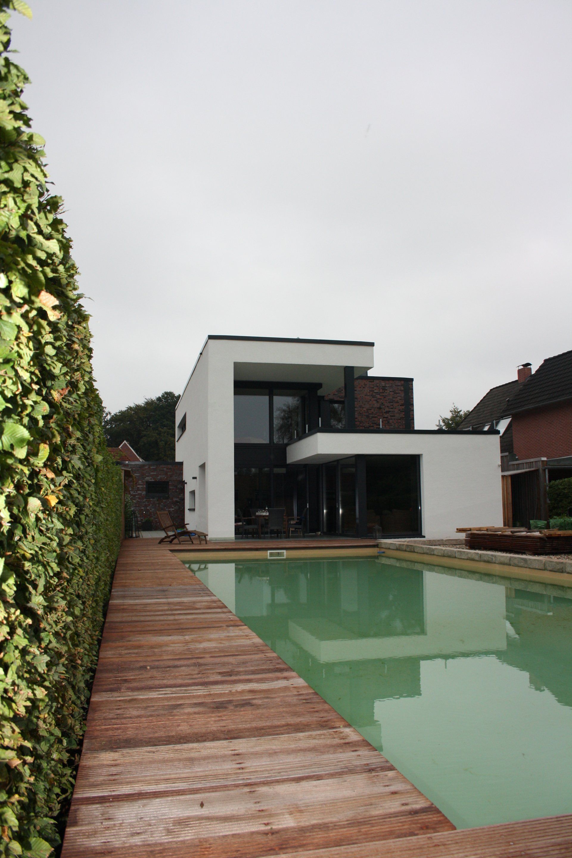 Ein modernes Haus mit einem großen Swimmingpool davor