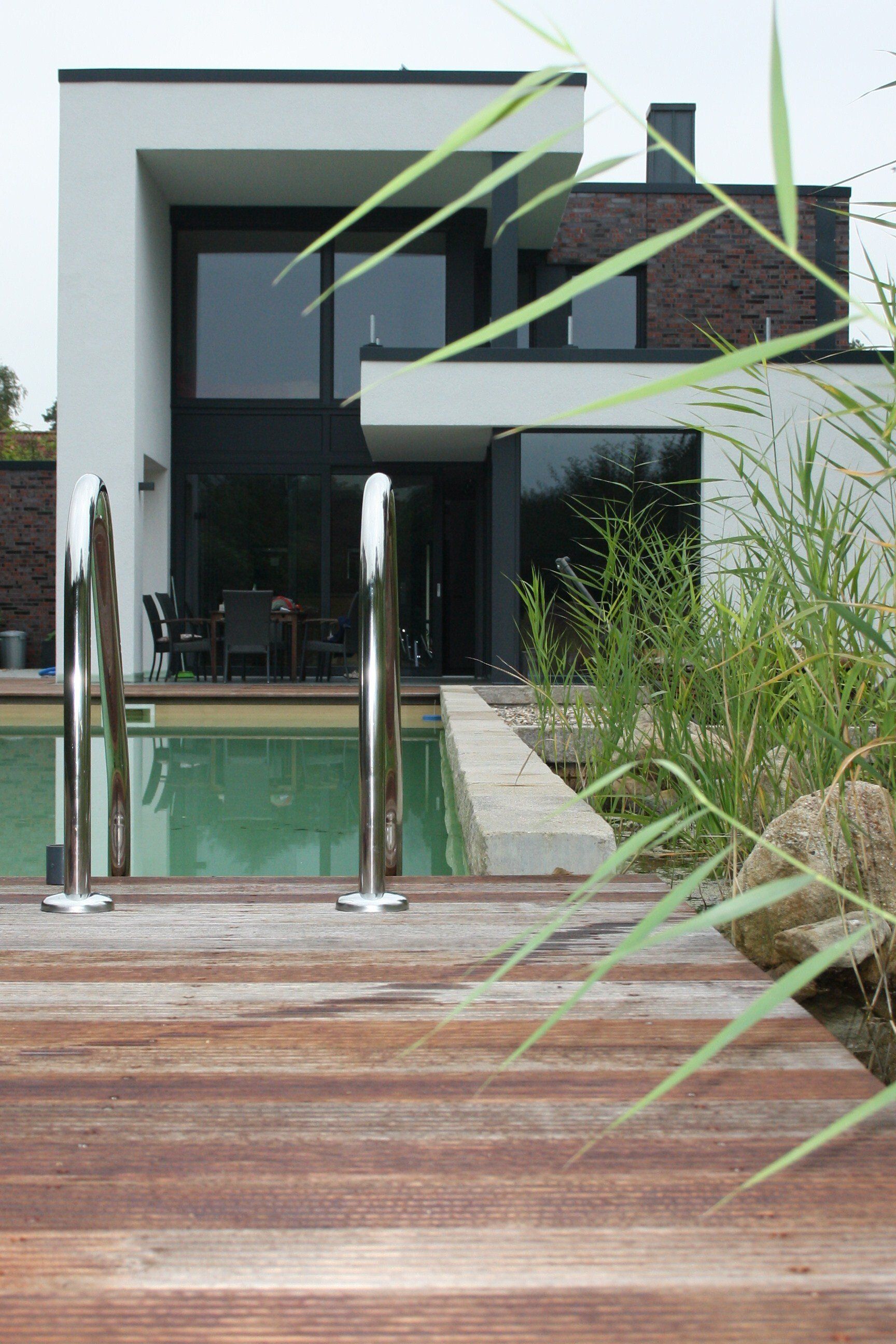 Ein modernes Haus mit einem Swimmingpool davor.