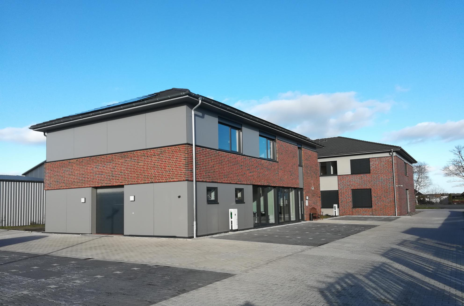 Ein großes Gebäude mit vielen Fenstern und einem Parkplatz davor