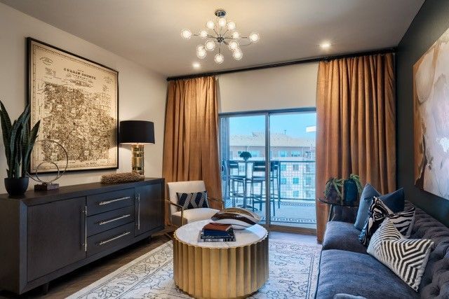 A living room with a couch , chair , coffee table and sliding glass doors.