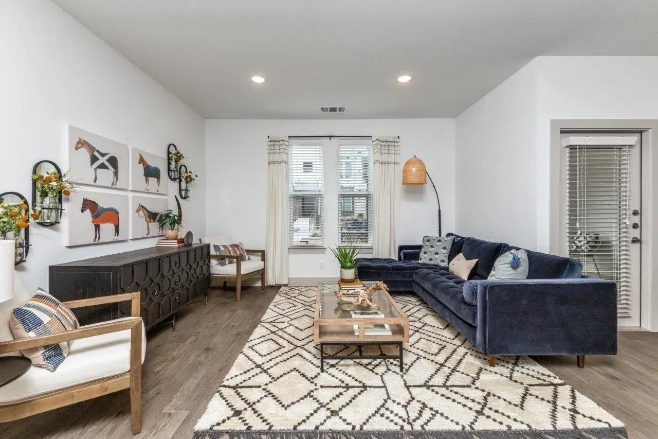 A living room with a couch , chairs , and a rug.