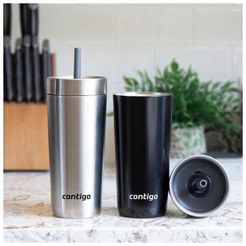 Two stainless steel tumblers with straws are sitting on a counter.