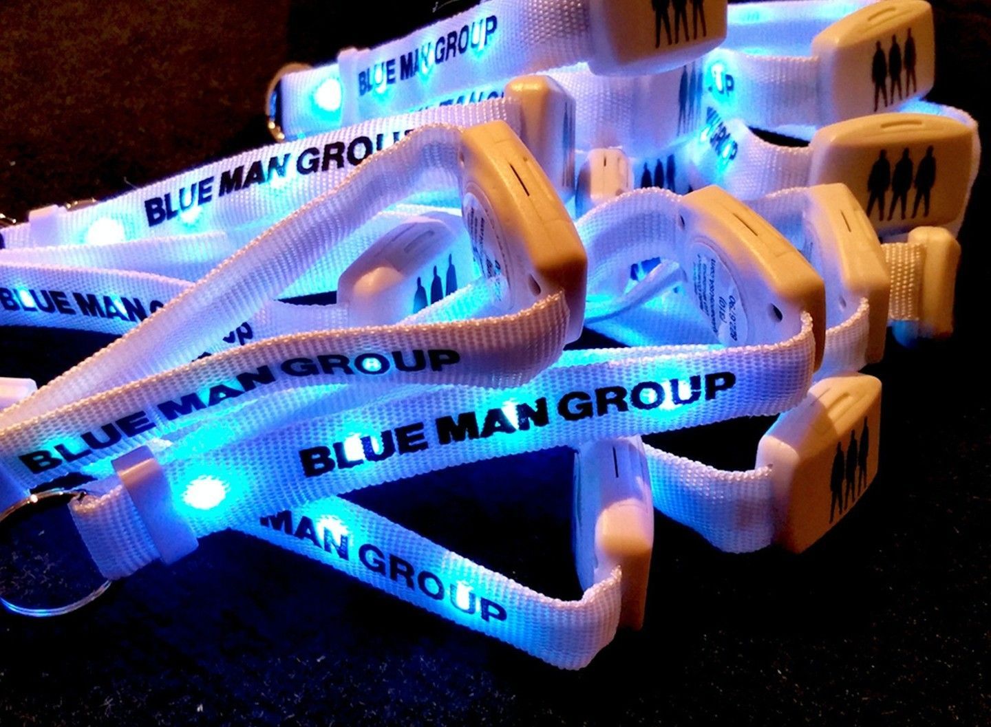 A bunch of blue man group lanyards are sitting on a table