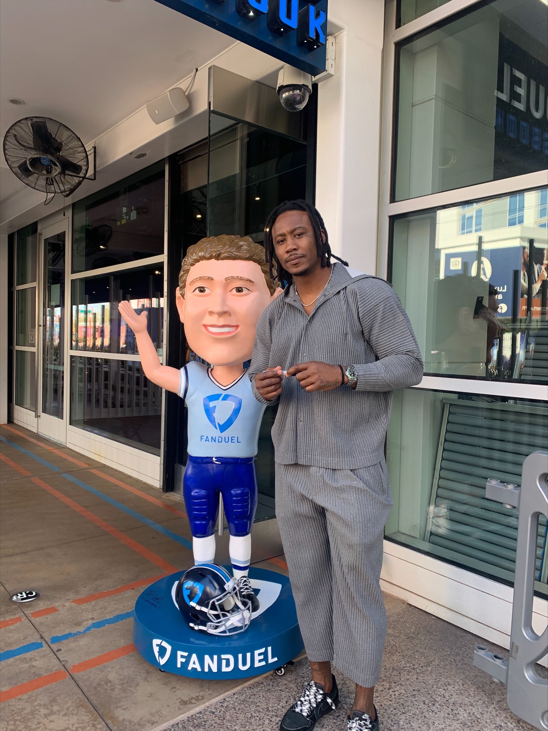 A glass sailboat figurine is sitting on a wooden table next to a box.