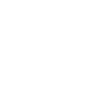 A delivery truck is driving through a city next to a factory.