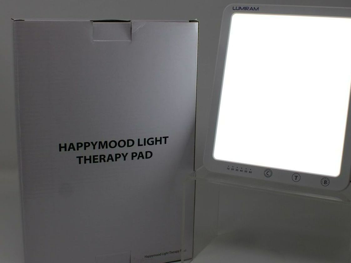 A happywood light therapy pad sits next to its box