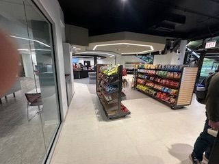 Interior of a store with shelves of snacks, a counter, and seating visible. UIC 
