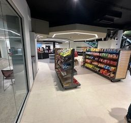 Interior of a store with shelves of snacks, a counter, and seating visible. UIC 