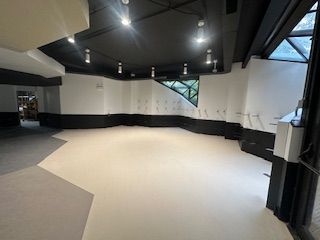 Empty interior room, white floor, black ceiling and trim, with accent window.UIC