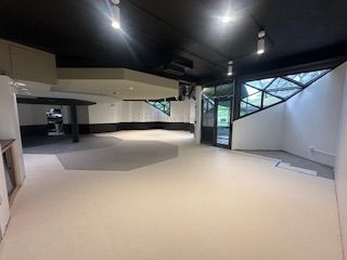 Empty interior space with black ceiling, light walls, and geometric windows. UIC