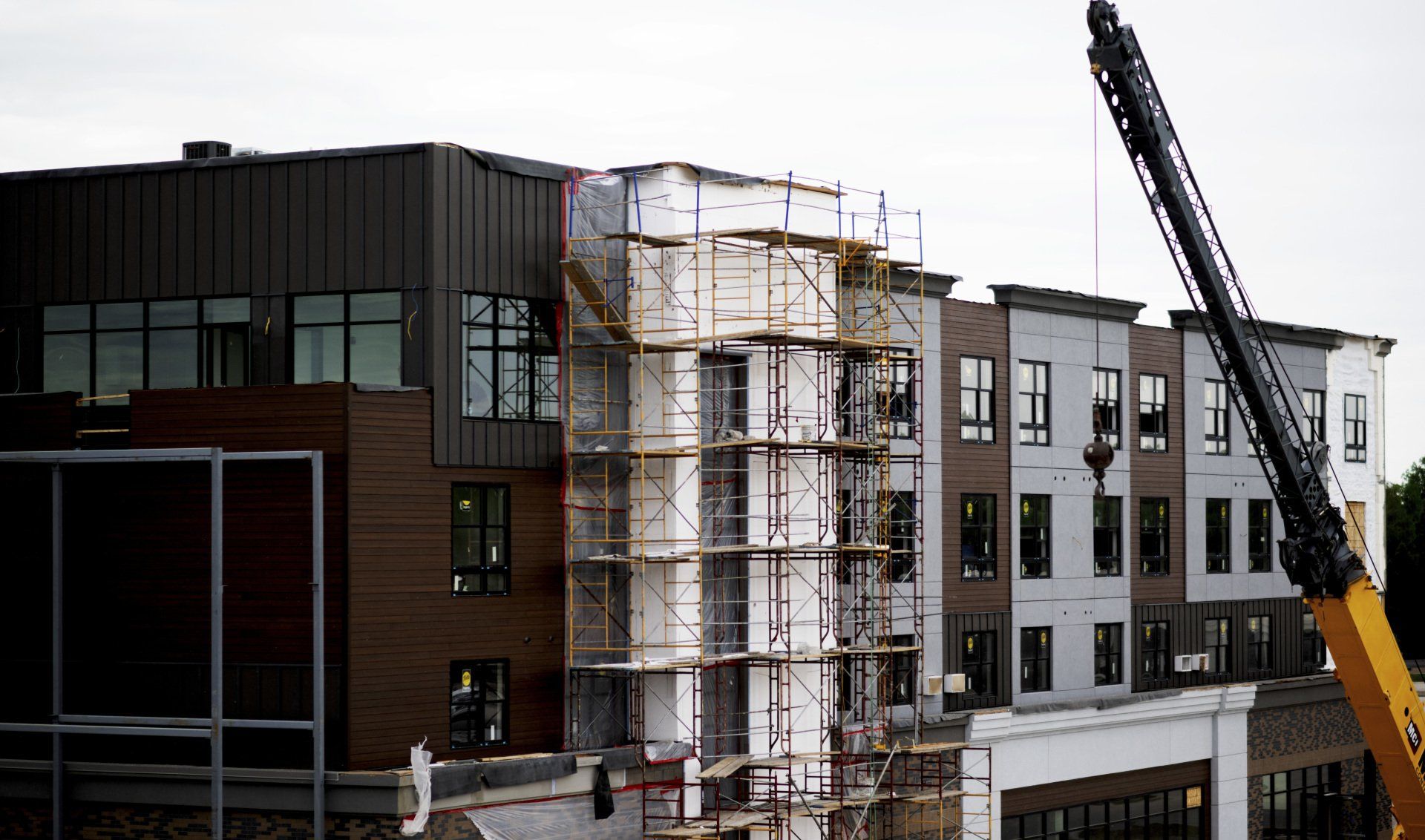 a large building under construction with a crane in front of it .