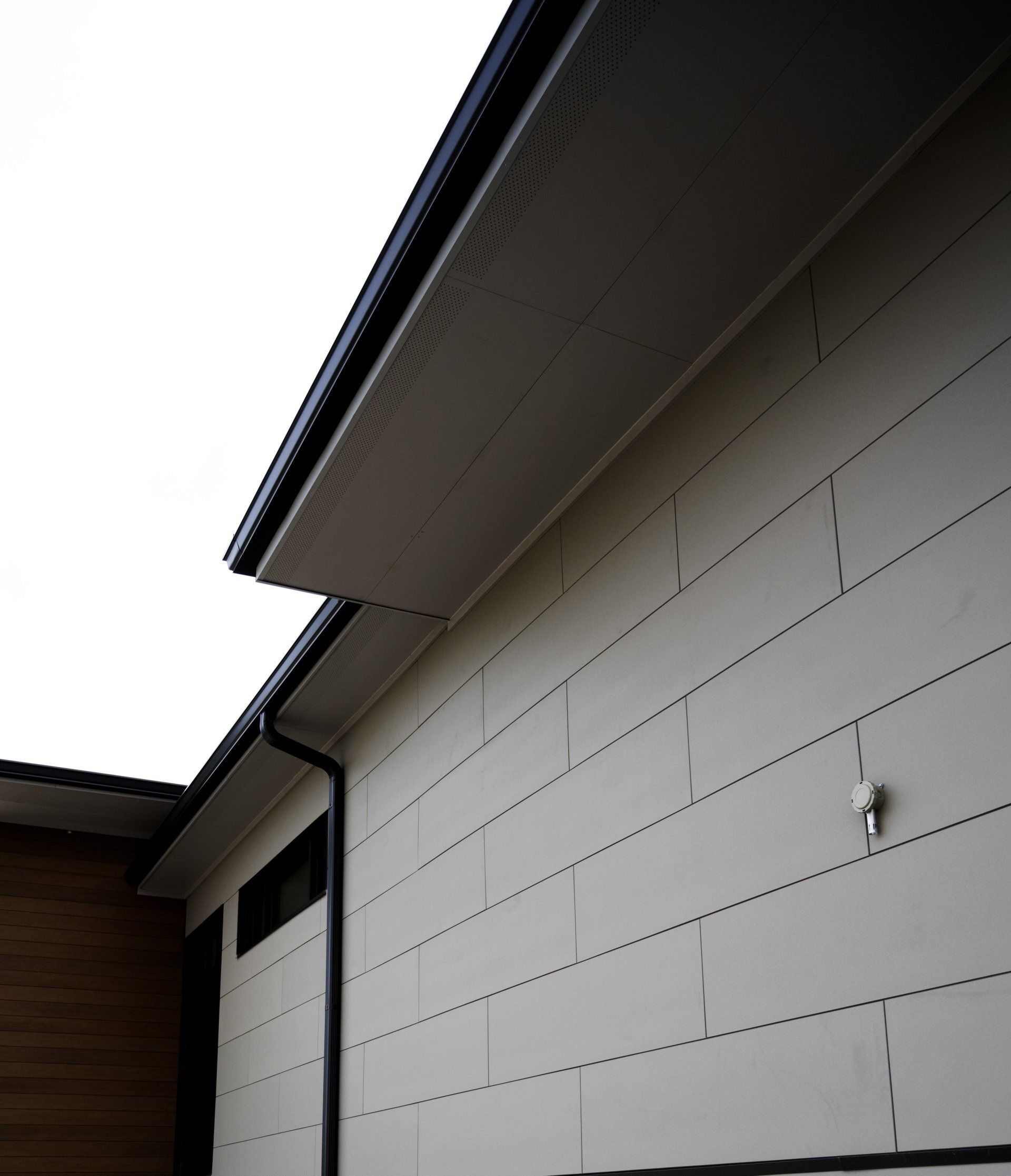 a white building with a black gutter on the side