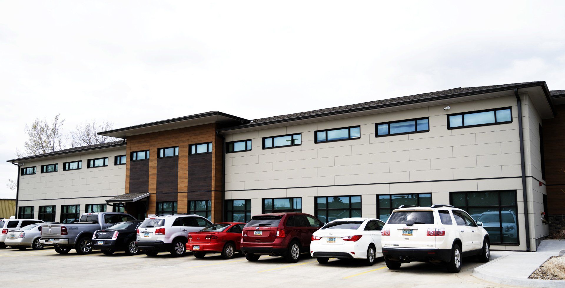 a row of cars are parked in front of a large building .