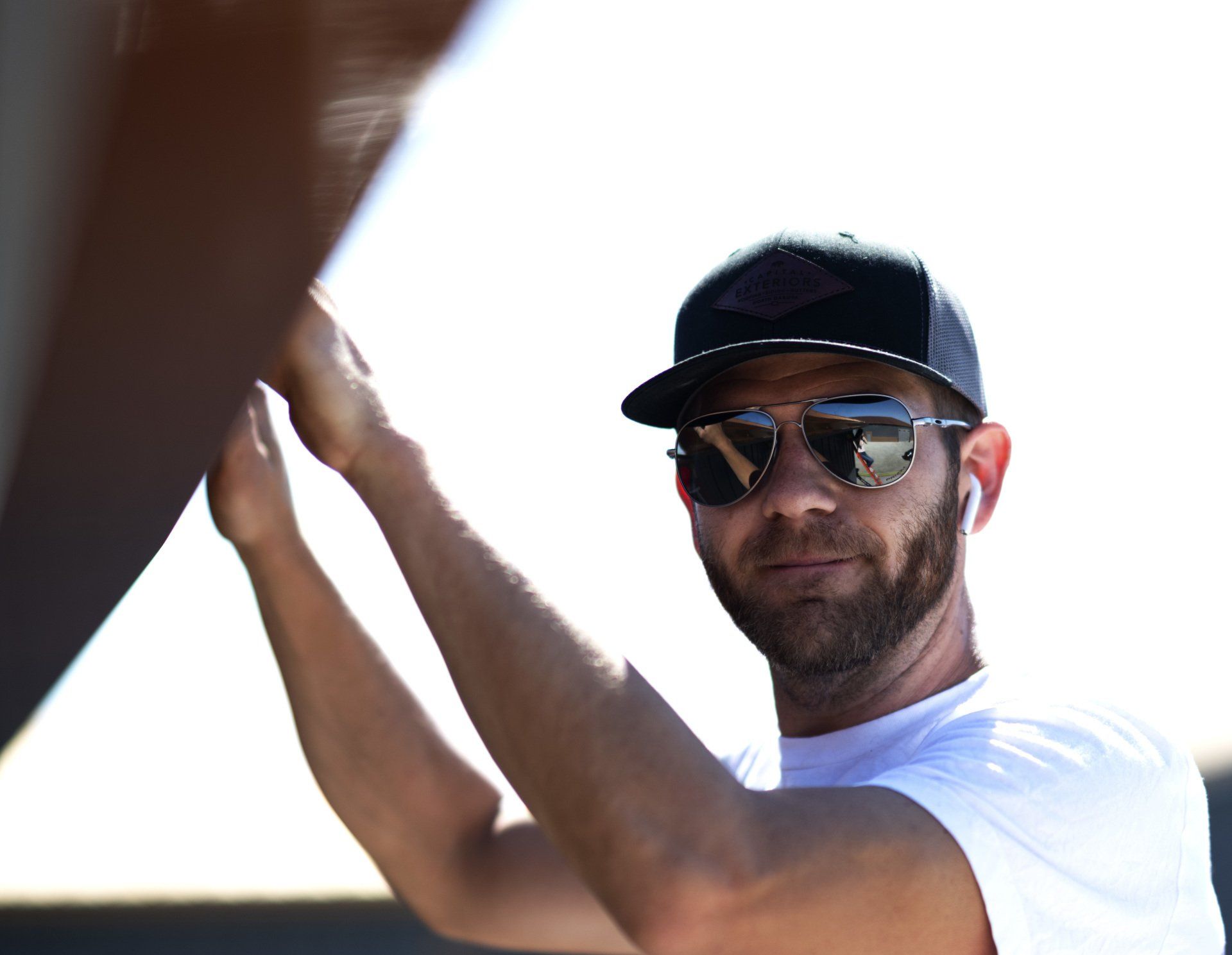 person wearing sunglasses working on gutter